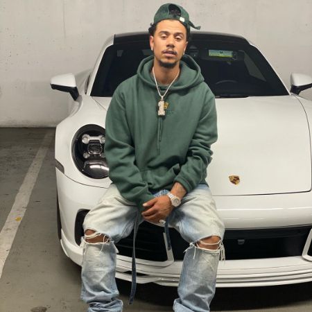 Lil' Fizz on his white car clicking a photo with dashy look.
